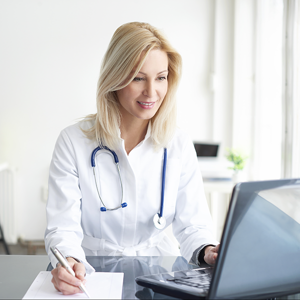 Sjúkrakallkerfi öflugur hugbúnaður frá Securitas. Ljóshærð kona læknir að nota tölvu