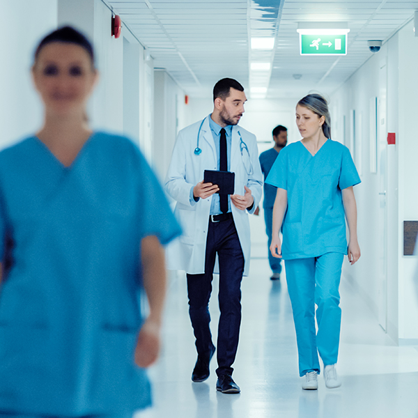 Yfirseta öryggisþjónusta frá Securitas öryggi starfsfólks og sjúklings. Læknir og hjúkrunarkonur á gangi.